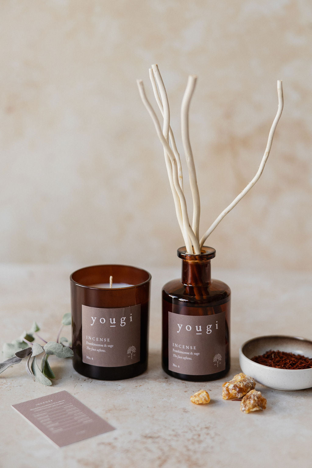 The Incense reed diffuser and candle in amber glass, with the scent card and a bowl of resin