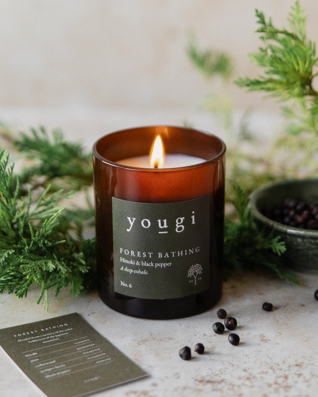 Forest Bathing candle lit in amber glass, with cypress and juniper berries