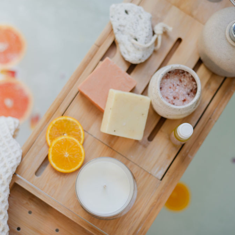 Homemade bath salts with essential oils by a bath.
