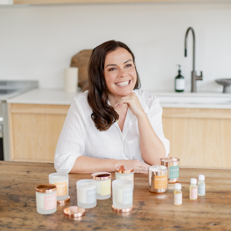 Yougi natural candles and oils arranged on a table.