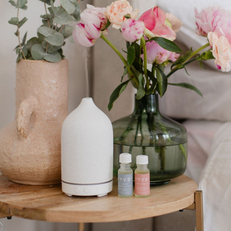 An essential oil diffuser releasing a soft mist.