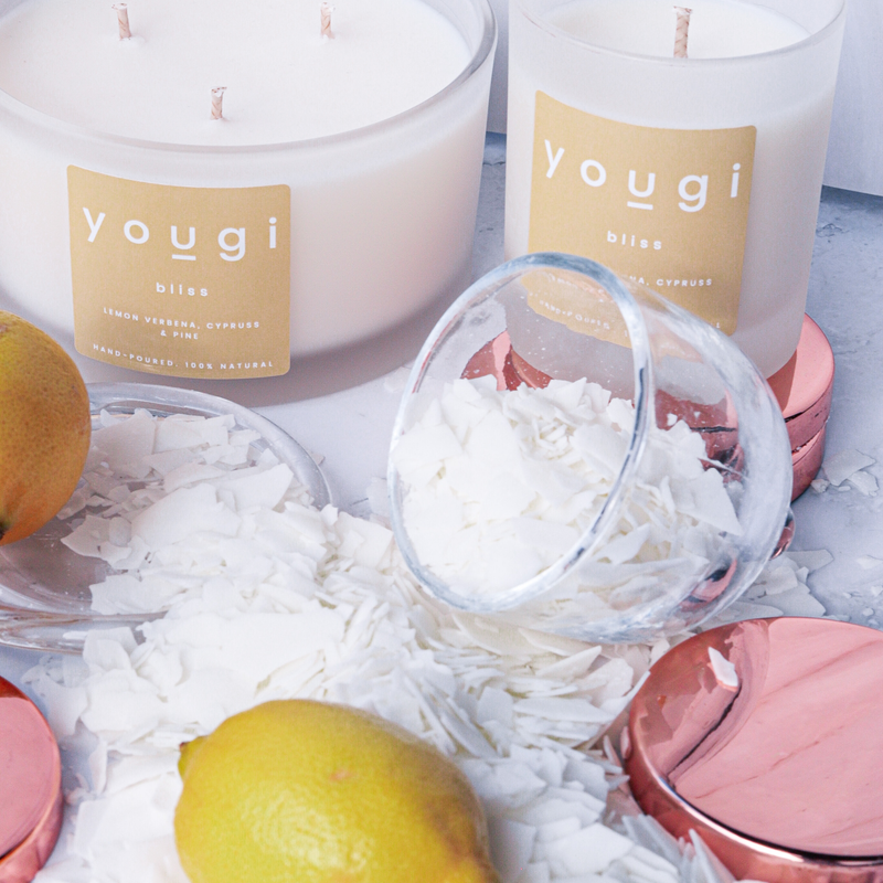Soy wax and a natural candle compared on a board.