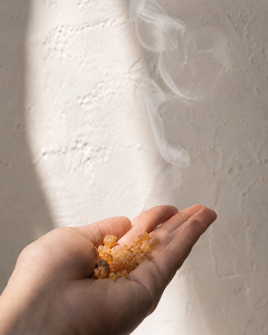 Manifest: frankincense resin in an open palm, a thread of smoke rising