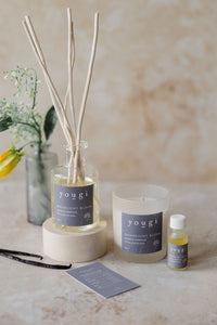 The Moonlight Bloom reed diffuser, candle and essential oil together on stone