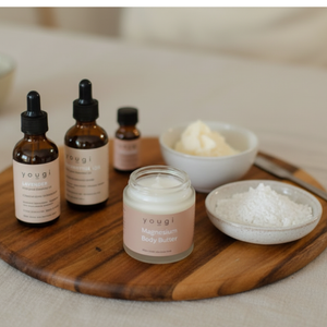 Yougi magnesium skincare products on a wooden board with a neutral background