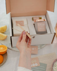 Stirring the New Romantic oil blend into the melted wax with the wooden stick from the kit