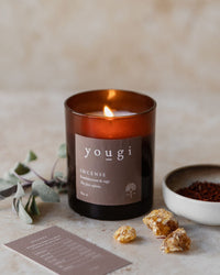 Incense candle lit in amber glass, with sage and frankincense resin