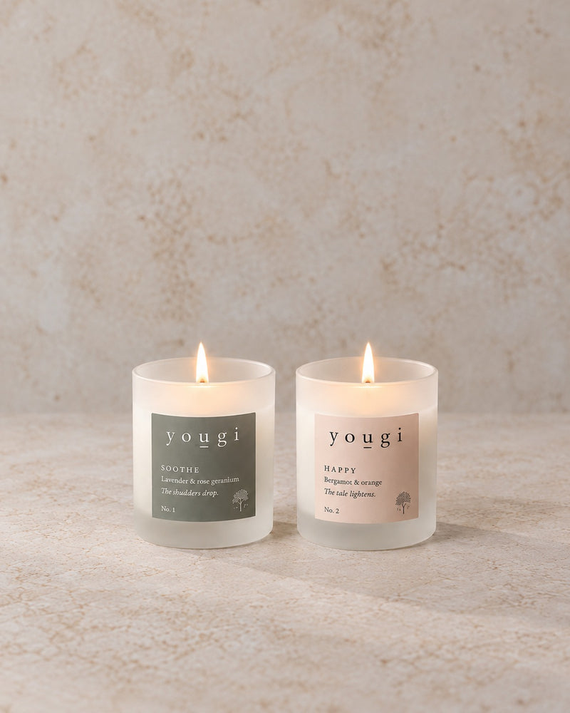 Soothe and Happy candles lit in frosted white glass
